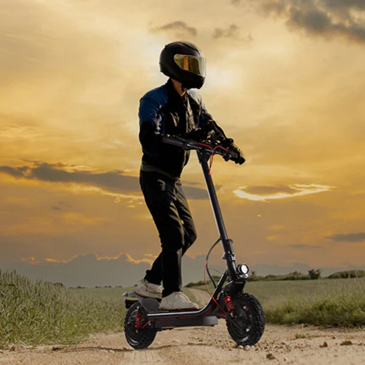 Person riding an electric scooter with a helmet on a sunset background